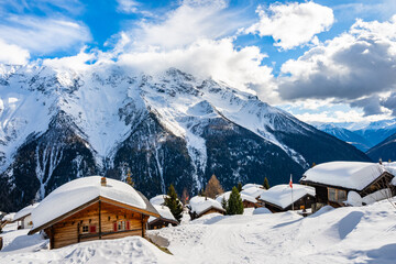 Traditional alpine wooden houses in winter mountain snow landscape, Loetschental valley, Switzerland