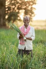 Indian farmer holding onion plant in hand
