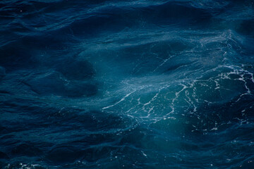 A sea wave trail with white foam and patterns on the water on the Mediterranean coast in Croatia