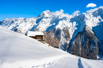 Winter snowy road with typical wooden houses in alpine village, Loetschental valley, Switzerland