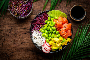 Poke bowl for balanced diet with salmon, avocado, radish, cabbage, beans, sesame and rice, wooden...