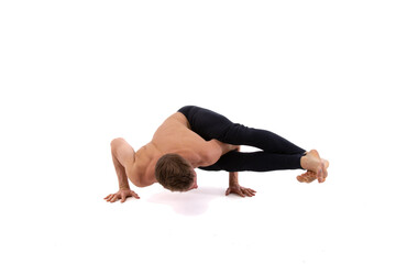 Sports and healthy lifestyle. An attractive man is doing yoga and pilates. White background.