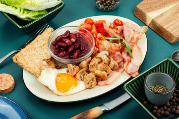 Breakfast with bacon, eggs, beans and mushrooms.