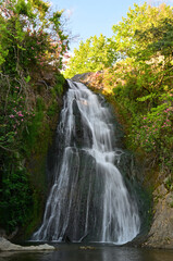 Obraz premium Nebiler Waterfall and Aglayan Cave, located in Dikili, Izmir, Turkey, is a tourist destination with a walking track and picnic area.