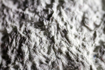 Extreme close up of old gray handmade paper mache with a structure and rough texture.