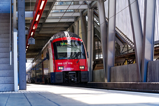 Low angle view of platform of railway station Hard Bridge with train leaving at Swiss City of Z&uuml;rich at industrial district on a sunny noon. Photo taken May 10th, 2024, Zurich, Switzerland.