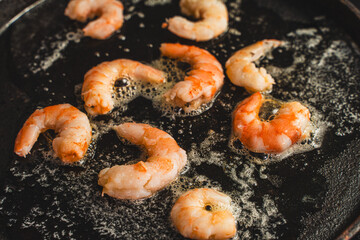 Close-up of shrimp fried in oil in a cast iron skillet, Cooking delicious king prawns. Selected...