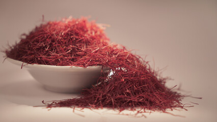 Fototapeta premium Dried saffron on ceramic cup. Isolated on gray background