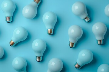 Multiple unlit, frosted light bulbs are uniformly arranged on a complementary blue background