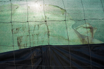 Metal wire fence and synthetic fabric.