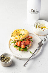 Homemade bagel sandwich with smoked salmon, cream cheese, capers and spinach for healthy breakfast...
