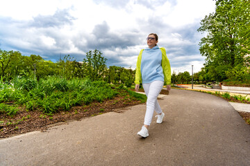 Spring walk - mid-adult beautiful woman walking in city park
