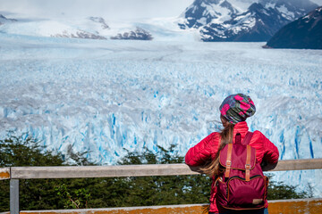 Mujer turista con campera roja disfrutando de las vistas del Glaciar Perito Moreno, en la Patagonia...