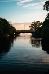 Fototapeta premium Evening Glow Over River with City Backdrop