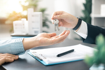 Real estate agent handed over the key to new home, marking a successful investment in business of...