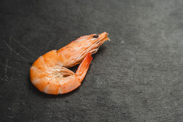 Shrimp on a black mica board. Close-up, space for text. Selected focus