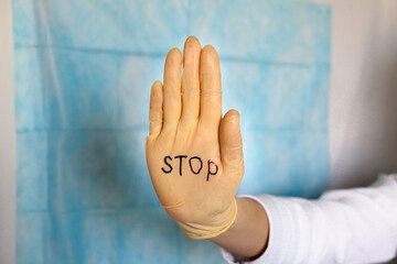Stop. Text on a medical glove.