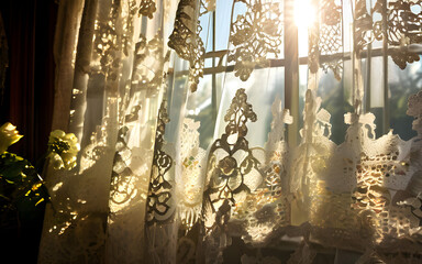 Sunlight filters through lace curtains.
