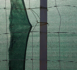 Metal wire fence and synthetic fabric.