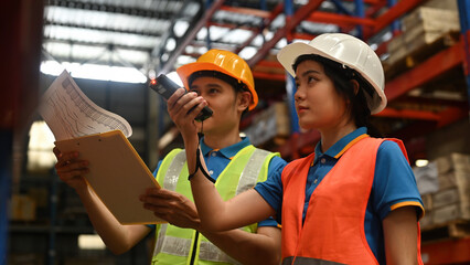 Female warehouse worker using bar code scanner to analyze and check goods in the storage department