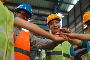 A group of diverse warehouse workers join hands together in a storage warehouse, Unity and teamwork...