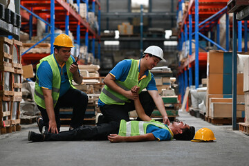 Warehouse workers first aid their friend after accidents or First aid training in an industrial...