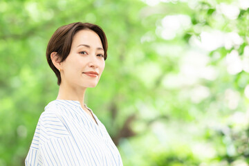 新緑の中でリラックスする女性