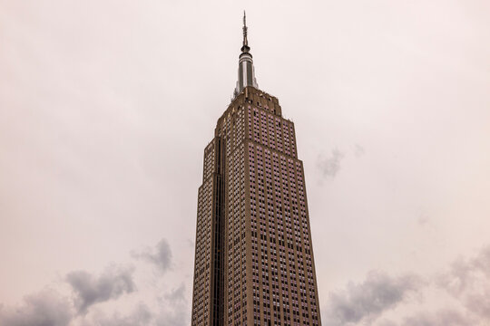 Stunning view of the Empire State Building towering above the New York City skyline against a backdrop of cloudy skies. New York. USA. 