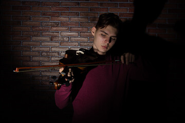 A young attractive guy is learning to play the violin.