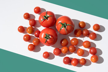 Surtido de tomates maduros sobre una mesa blanca y fondo verde	