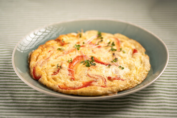 Healthy breakfast concept. Whipped eggs fried with red sweet pepper on a plate. Delicious hot omelette diet food