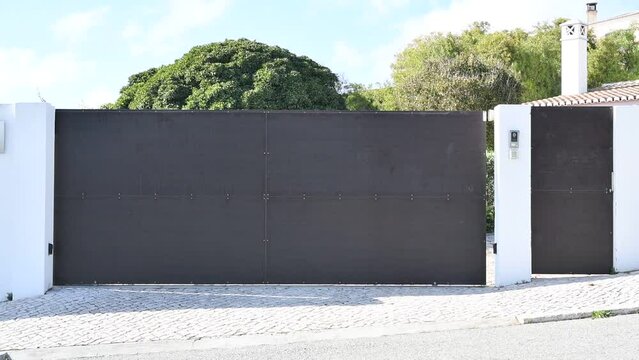 Electric sliding gate at the entrance to a driveway opening sideways