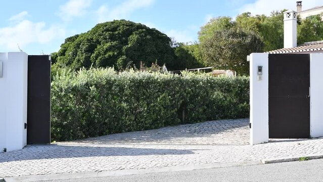 Electric sliding gate closing at the entrance to a driveway