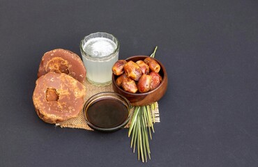 Date Palm Liquid Jaggery in a Glass Bowl, Phoenix Dactylifera Fruit and Date Palm Tree Juice Isolated on Black Background with Copy Space