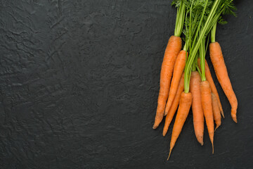 Bunch of fresh carrots on concrete background, top view