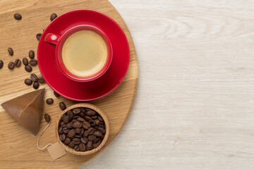 Cup of coffee made using pyramid on wooden background, top view