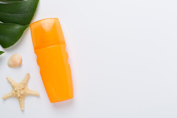 Sunscreen lotion with summer decor on color background, top view