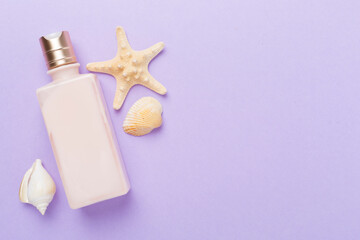 Sunscreen lotion with summer decor on color background, top view