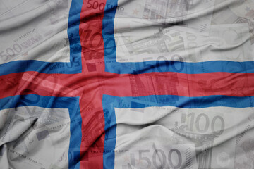 waving colorful national flag of faroe islands on a euro money banknotes background. finance concept.