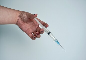 Hand with brown nail polish holding syringe medical themed object photography isolated on...