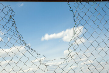 Broken metal mesh fence