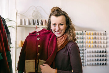 Joyful Woman Holding a Stylish Red Jacket in a Boutique, Store Concept