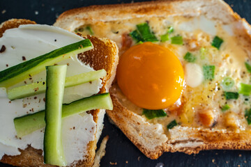 A delicious and healthy breakfast close-up. On a black mica board, toasted toast with egg, cheese...