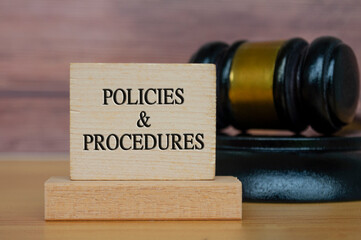 Policies and procedures text engraved on wooden block. Legal and law concept.