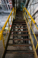 Abandoned old industrial building with metal stairs and yellow railings