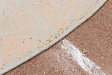 detail of a pitcher's mount tarp with infield clay and pitcher's line