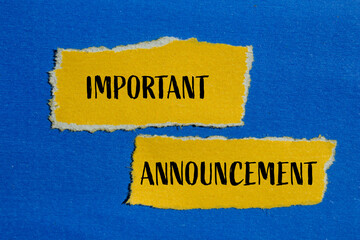Important announcement words written on ripped yellow paper pieces with blue background. Conceptual...