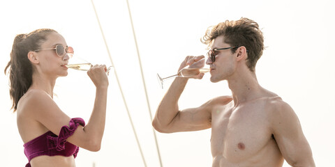 Young couple drinking or clinking glass of champagne or white wine in their honeymoon or...