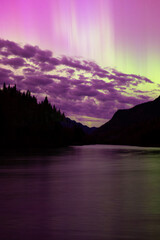 Vertical view of beautiful magenta aurora borealis and pillars of light reflected in river in the...