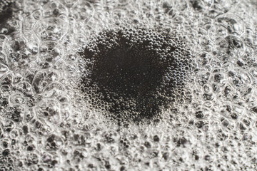 The background is boiling water in a black frying pan. The water bubbles in a black pan. Space for...